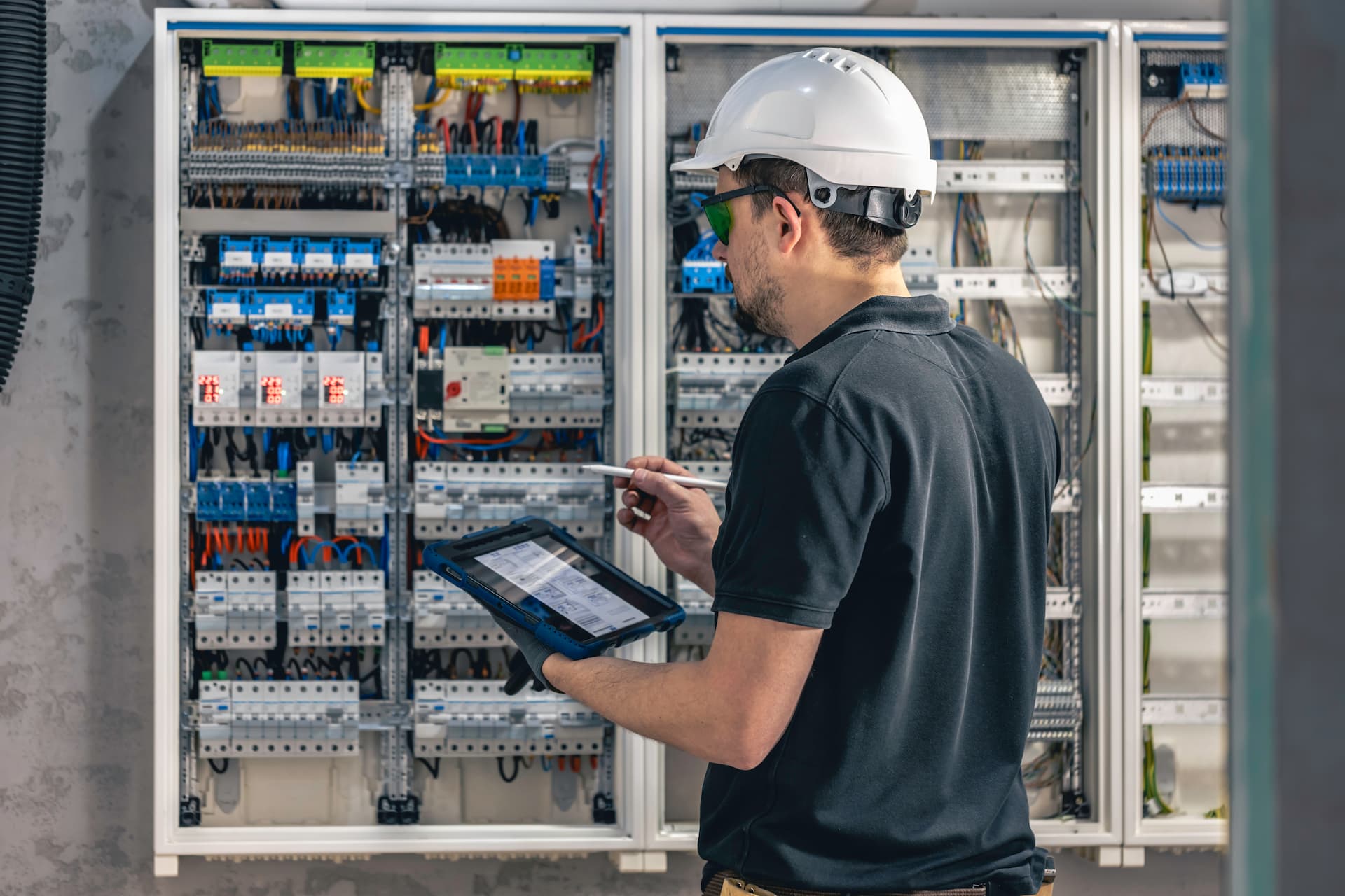 Ein Elektroniker vor einem Schaltkasten